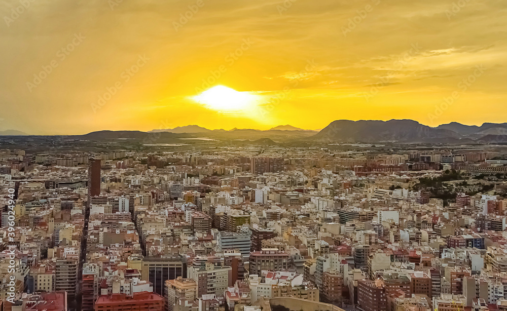 Spanish Mediterranean aerial cityscape with mountains on sunset.