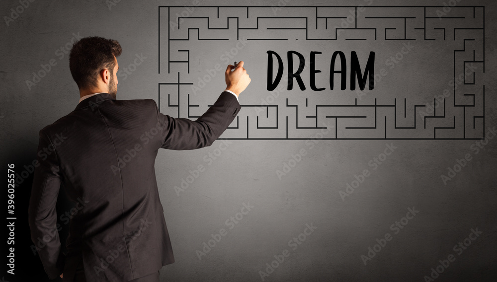 businessman drawing maze with DREAM inscription, business education concept businessman drawing maze with DREAM inscription, business education concept