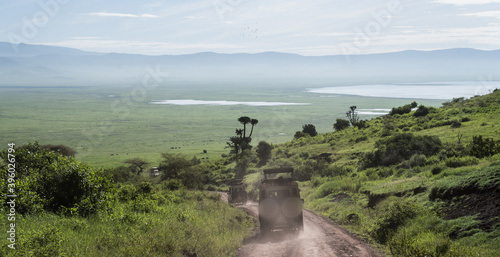 Safari truck driving into the Ngorongoro crater with view over the lakes photo