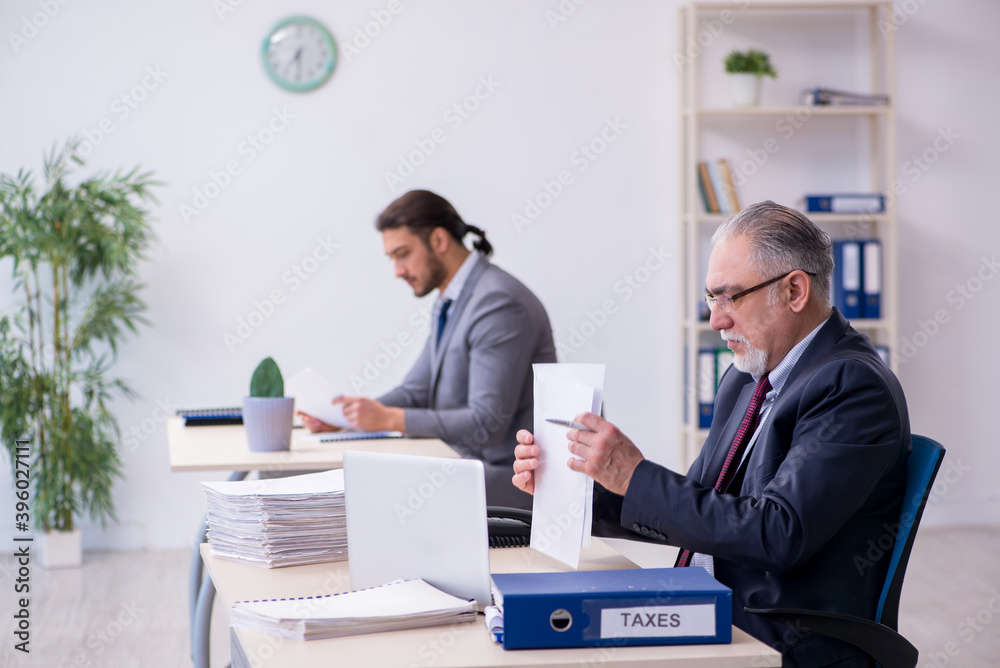 Old boss and his young assistant working in the office