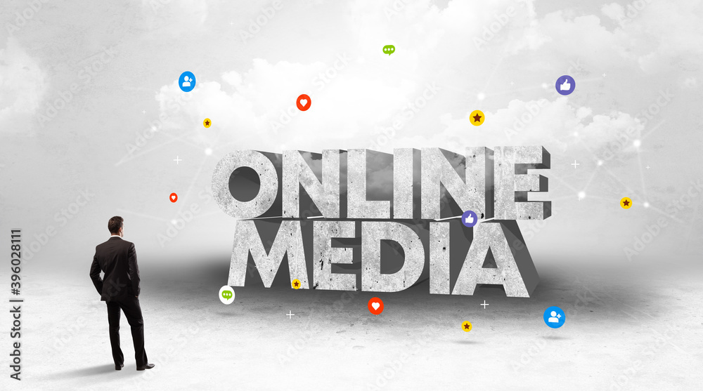 Young businessman standing in front of ONLINE MEDIA inscription, social media concept Young businessman standing in front of ONLINE MEDIA inscription, social media concept