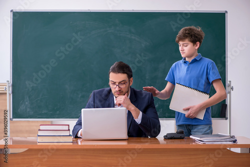 Young male teacher and schoolboy in the classroom © Elnur