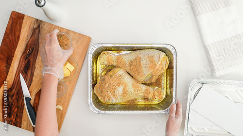 фотографія Spicy marinated turkey legs  in a disposable bake-ware pan, ready to be cooked, close up view from above