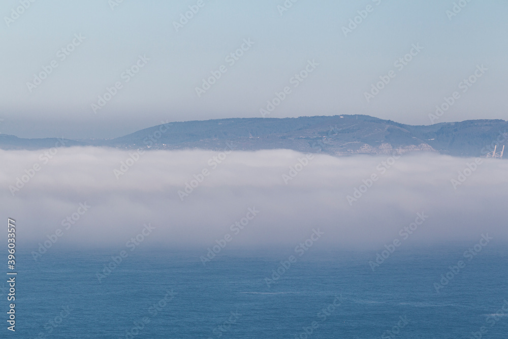 fog bank over the sea with mountains