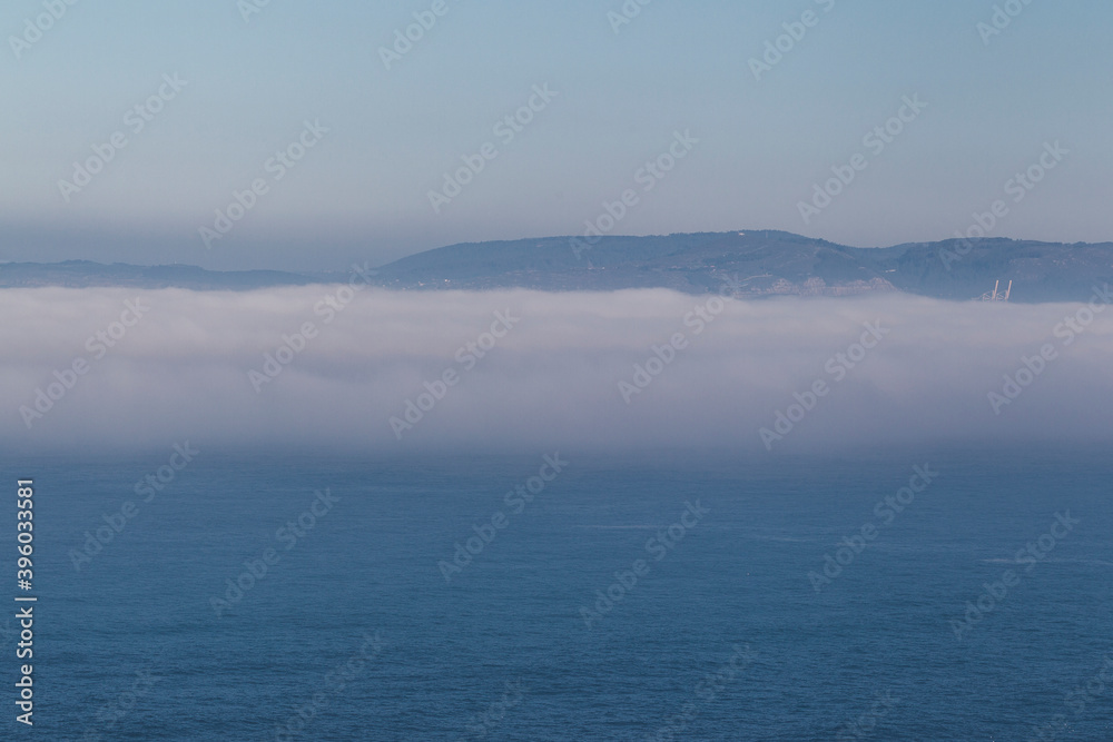 fog bank over the sea with mountains