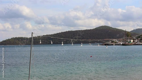 View of sea and landscape in Turkbuku in Bodrum peninsula. Bulbs hung on a string swing by wind in summer. photo