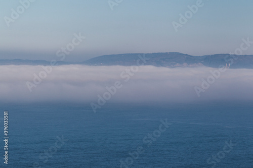 fog bank over the sea with mountains © Imaxepress