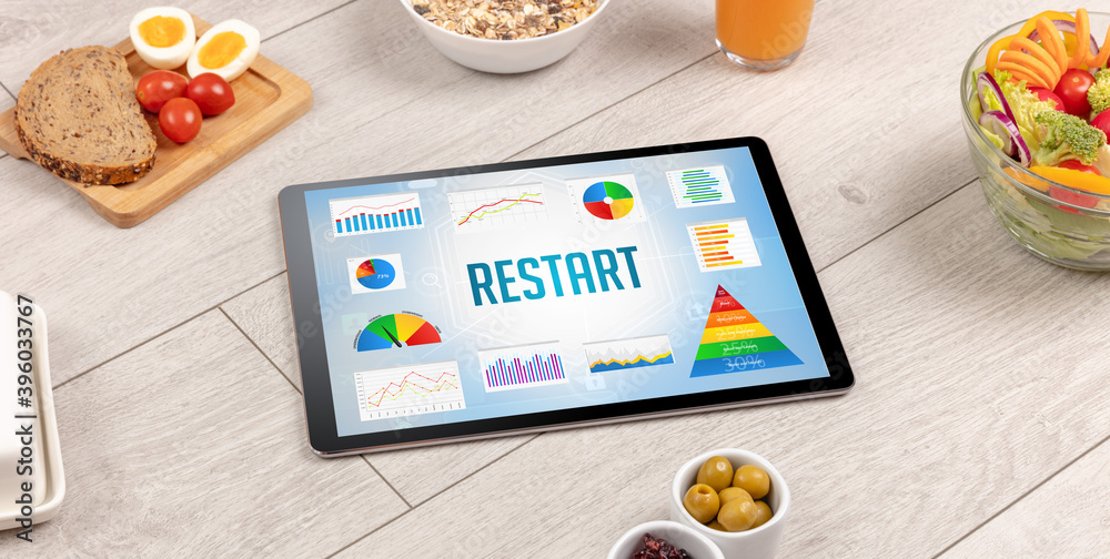 Organic food and tablet pc showing RESTART inscription, healthy nutrition composition Organic food and tablet pc showing RESTART inscription, healthy nutrition composition