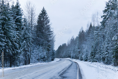 Snowy road in winter forest. Beautiful frosty white landscape.