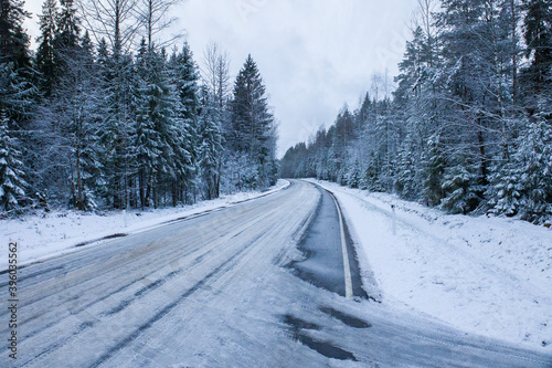 Snowy road in winter forest. Beautiful frosty white landscape.