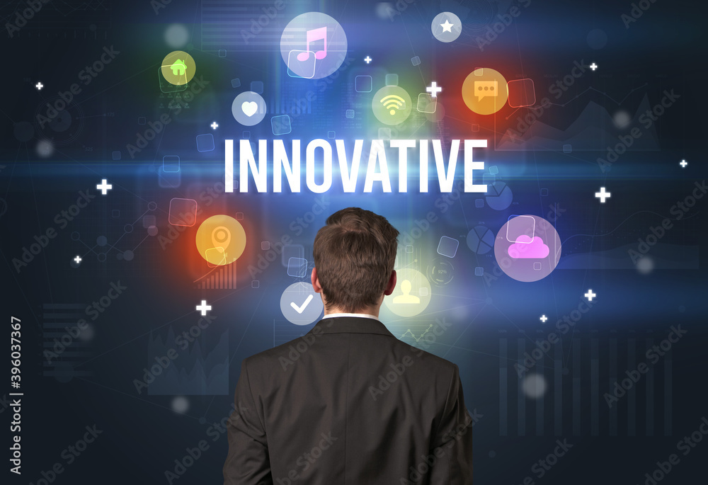Rear view of a businessman with INNOVATIVE inscription, modern technology concept Rear view of a businessman with INNOVATIVE inscription, modern technology concept