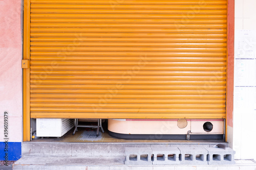 A closeup shot of automatic metal roller door used in factory, storage, garage, and industrial warehouse. The corrugated and foldable metal sheet offer space saving and provide urban and rustic feel