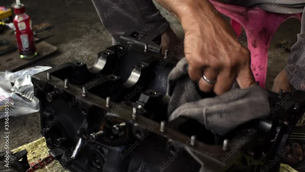 Car engine repair technician wiping engine block Car engine repair technician wiping engine block
