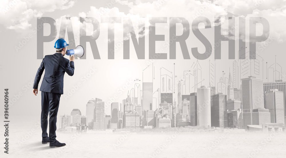 Young businessman with hard hat and PARTNERSHIP inscription, new business opportunity concept Young businessman with hard hat and PARTNERSHIP inscription, new business opportunity concept