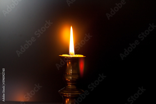 A burning candle in a candle stand