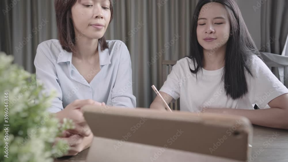 Private tutor home school, Asian teacher giving student advice during tuition hour, online learning media, wireless tablet writing down knowledge information, Education course lesson, study at home Private tutor home school, Asian teacher giving student advice during tuition hour, online learning media, wireless tablet writing down knowledge information, Education course lesson, study at home