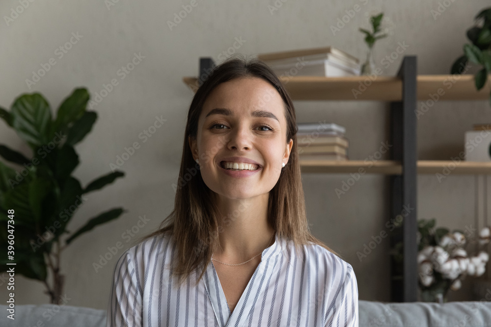 Headshot portrait of smiling young Caucasian woman look at camera speak talk on video call. Profile picture of happy millennial female have pleasant webcam digital virtual conference online.