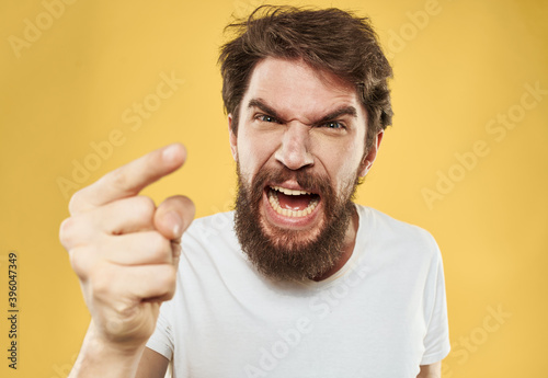 A man gestures with his hands on a yellow background Copy Space