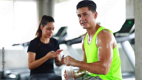 sportsman taking a break after training at the gym sitting and drinking water photo