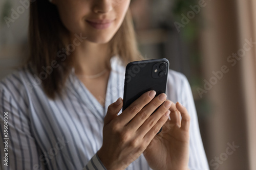 Crop close up of woman hold modern smartphone browsing surfing wireless internet on gadget. Happy female client or customer use cellphone device, text or message or shop online. Technology concept.