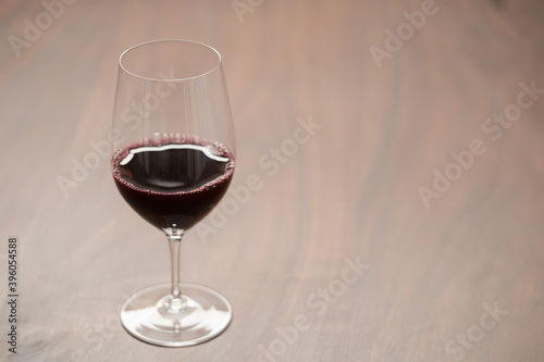 Red wine in wineglass on black walnut table with copy space