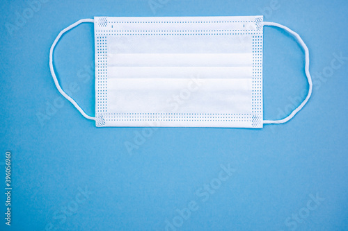 Antibacterial medical mask for children of white color on a blue background. Coronavirus Protection concept.