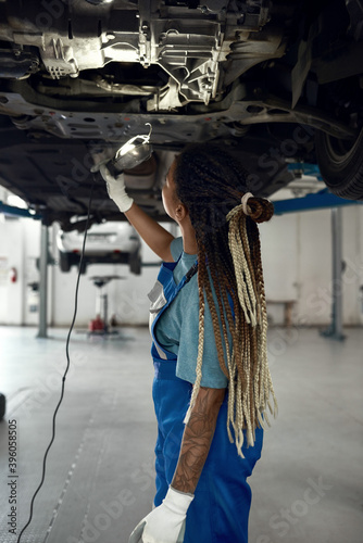 Young afro american girl techician at car service station photo