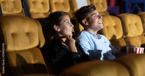 Young woman with friends watching movie in cinema . diversity people watching movie in cinema theater with popcorn and drinks. © NVB Stocker