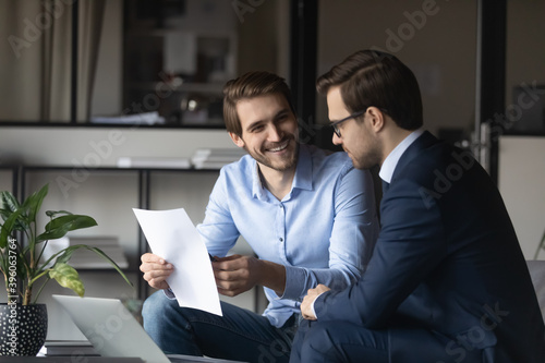 фотографія Friendly elder male employee mentor leader explaining paperwork to younger newbi