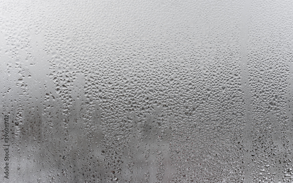 Close up water drop on grey background, misted glass with droplets of water draining down. Dripping Condensation Close up water drop on grey background, misted glass with droplets of water draining down. Dripping Condensation