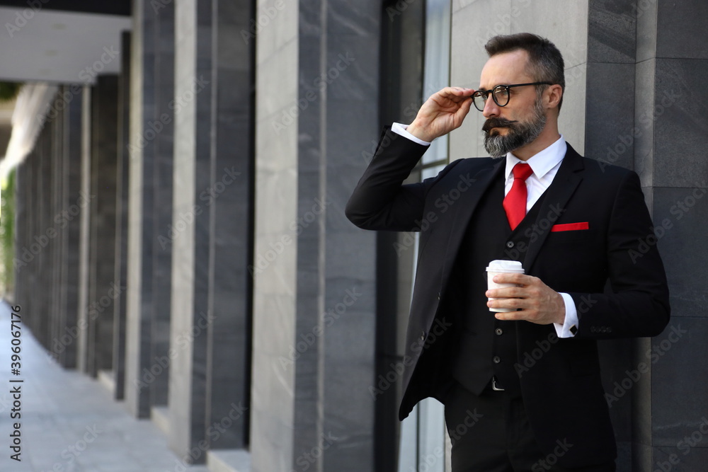 Handsome Caucasian business man holding take away coffee cup watching outside apartment in the morning before going to work Handsome Caucasian business man holding take away coffee cup watching outside apartment in the morning before going to work