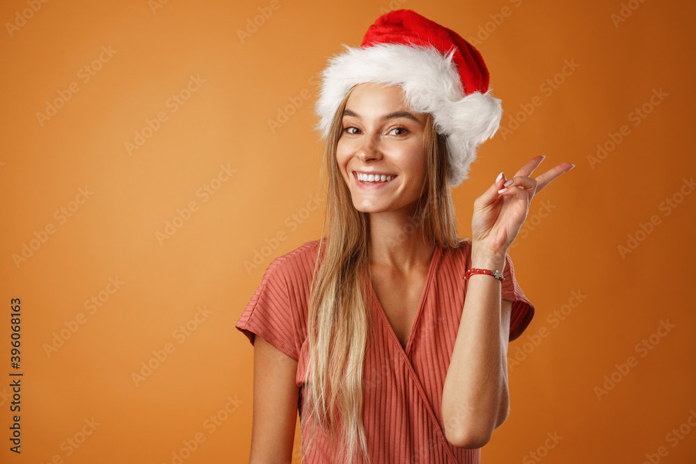 Cheerful young blonde woman wearing Santa hat.