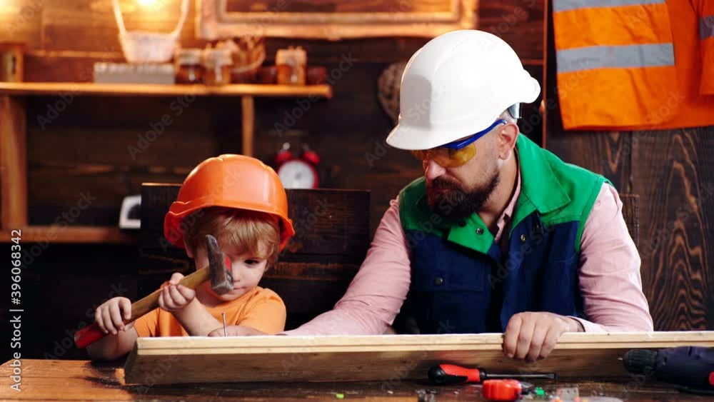 Dad shows his son how to make diy in wooden workshop using hammer and nail. Dad shows his son how to make diy in wooden workshop using hammer and nail.