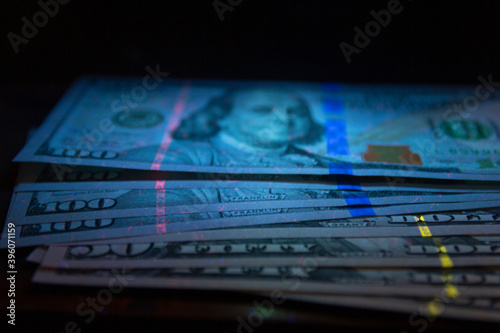 100 dollars banknot currency in UV light protection.Dollars in UV light.Dollars currency in UV light protection.