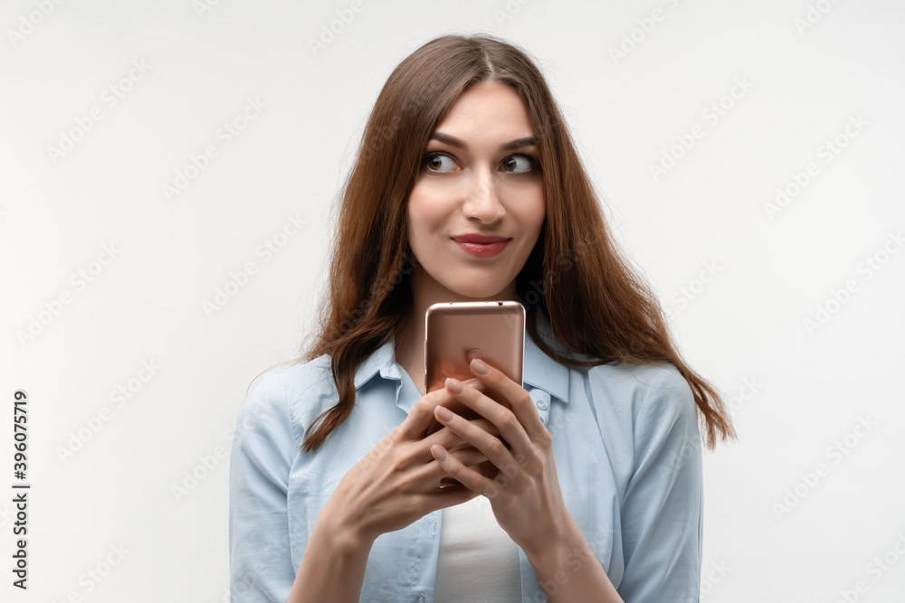Happy Young woman is using smartphone on white background. New useful application. Happy Young woman is using smartphone on white background. New useful application.