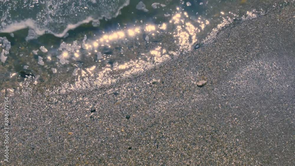 sea water reaches the shore covering the sand, sun shines on the water
sea water reaches the shore covering the sand, sun shines on the water