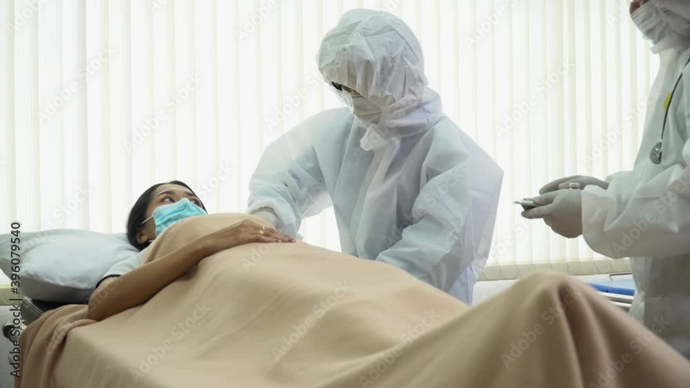 group of asian doctor wearing ppe suit vaccinating the infection and treating patients from coronavirus or covid 19 on bed in quarantine room at hospital . flu outbreak group of asian doctor wearing ppe suit vaccinating the infection and treating patients from coronavirus or covid 19 on bed in quarantine room at hospital . flu outbreak