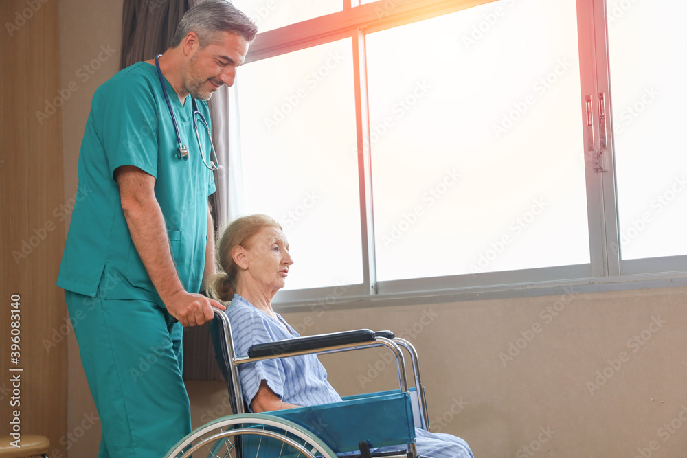 Doctor or assistance staff help or assist an elder patient woman while sitting on wheelchair in the hospital, healthcare or eldercare concept Doctor or assistance staff help or assist an elder patient woman while sitting on wheelchair in the hospital, healthcare or eldercare concept
