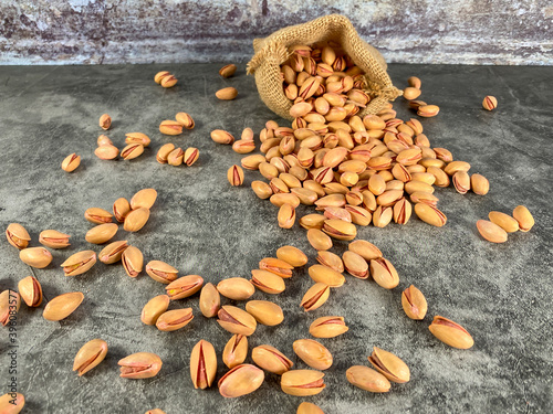 Roasted salted pistachios. Dried pistachios in small sack on  table.