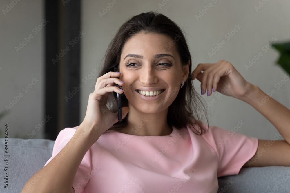 Head shot close up happy beautiful mixed race woman answering mobile phone call, involved in pleasant conversation with friends or family, sharing life news, distant telephone communication concept. Head shot close up happy beautiful mixed race woman answering mobile phone call, involved in pleasant conversation with friends or family, sharing life news, distant telephone communication concept.