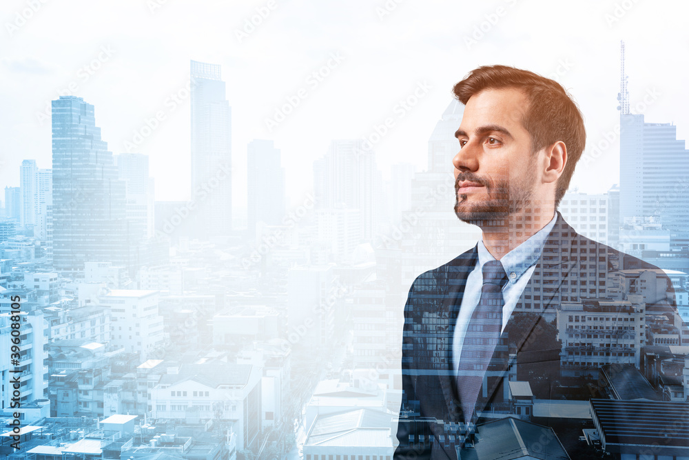 Fototapeta premium Young handsome businessman in suit thinking how to succeed, new career opportunities, MBA. Bangkok on background. Double exposure.