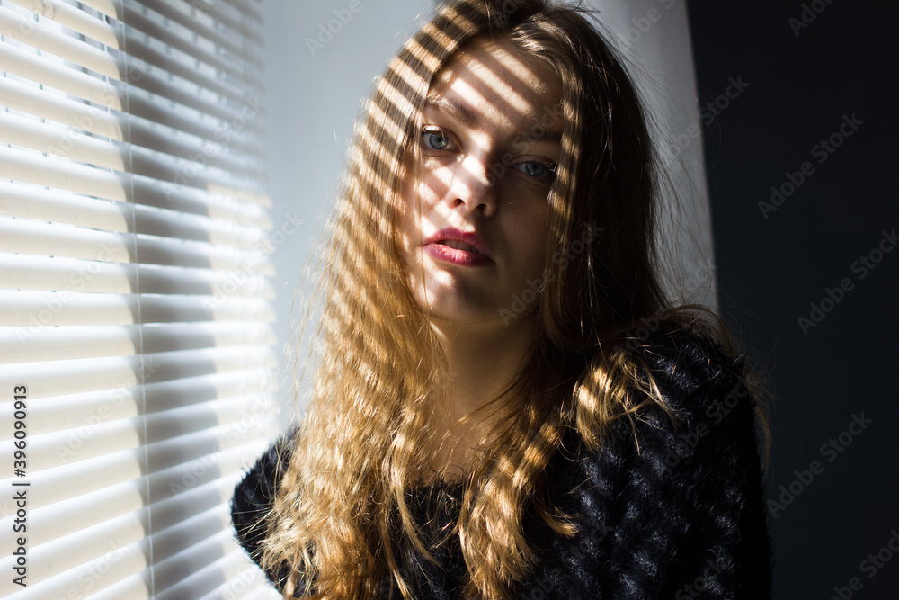 Portrait of a young woman with shadows on her face. girl with blonde hair Portrait of a young woman with shadows on her face. girl with blonde hair