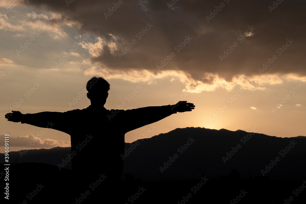 Man with arms extended toward heaven at sunrise ,success or prayer concept Man with arms extended toward heaven at sunrise ,success or prayer concept