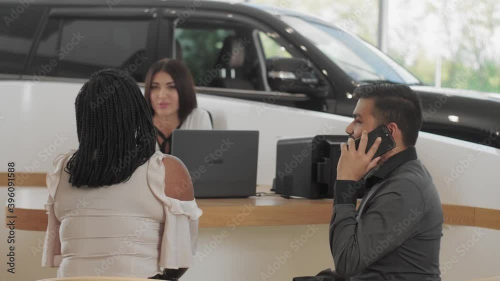 Visiting a car dealership choosing and buying a new car. A young