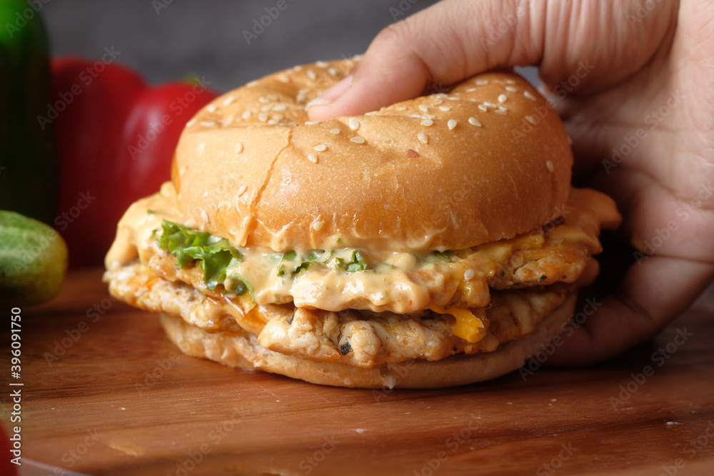 hand holding beef burger on table close up hand holding beef burger on table close up