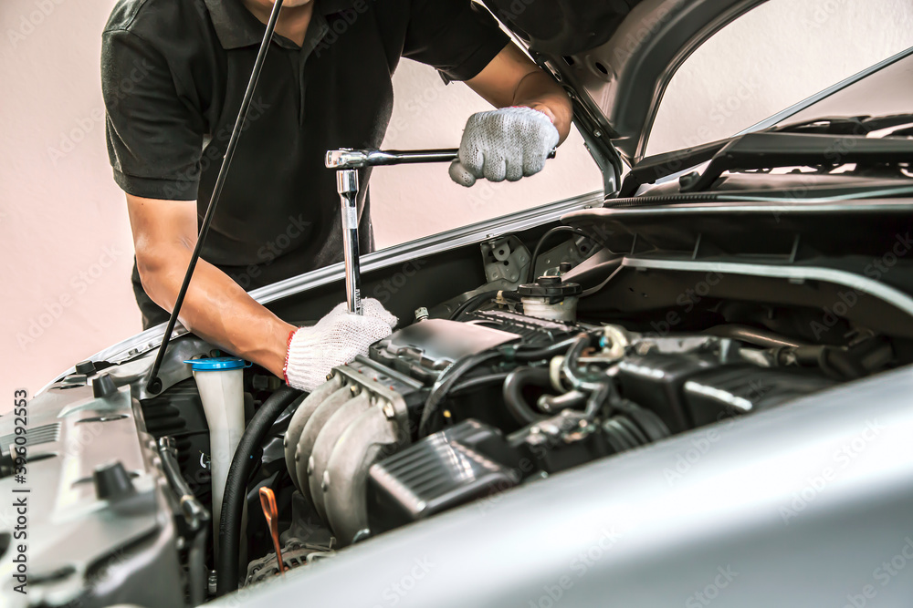 Obraz premium Close-up hands of auto mechanic are using the wrench to repair and maintenance auto engine is problems at car repair shop. Concepts of car care check and fixed and services insurance.