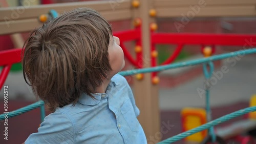 The boy lies on the sports net and looks around