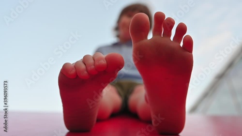 Boy warms his fingers serenely on the red roof