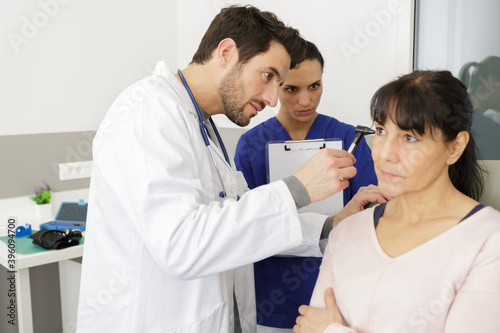 attentive doctor doing ear exam of woman