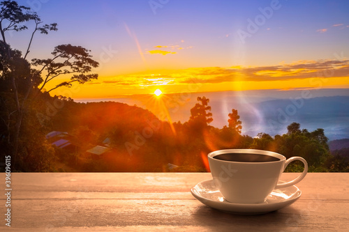 Close up coffee cup on wood table at sunset or sunrise background